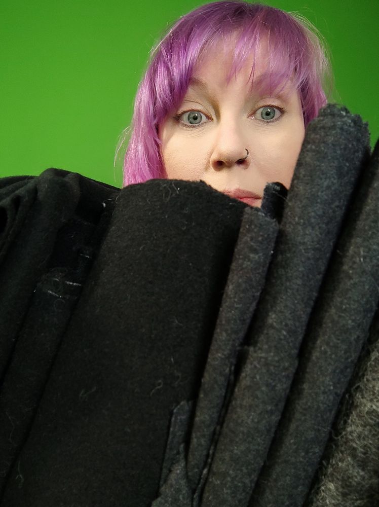 poster myself Hebe holding a large amount of fabrics in front of me