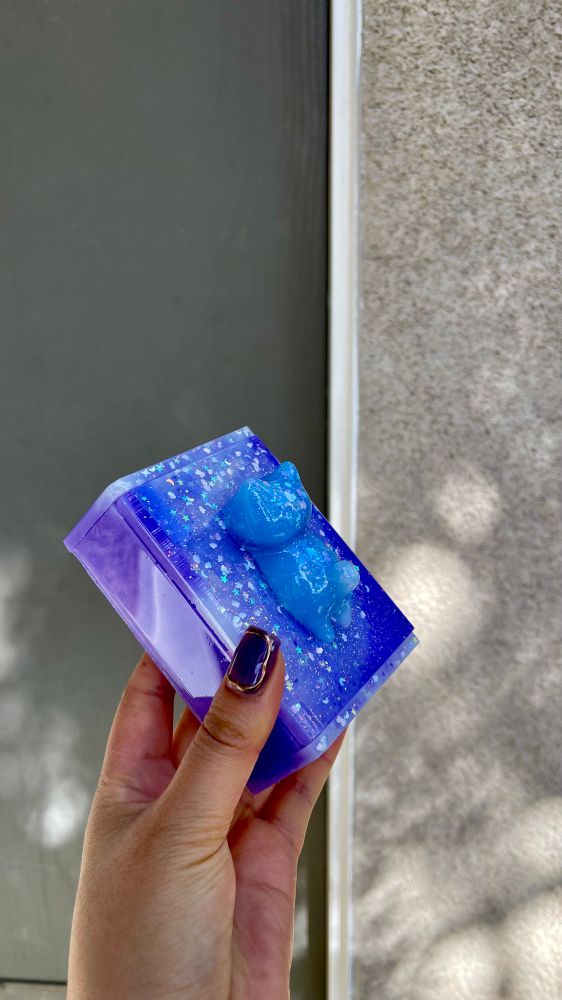 Blue cat attached to purple glitter box