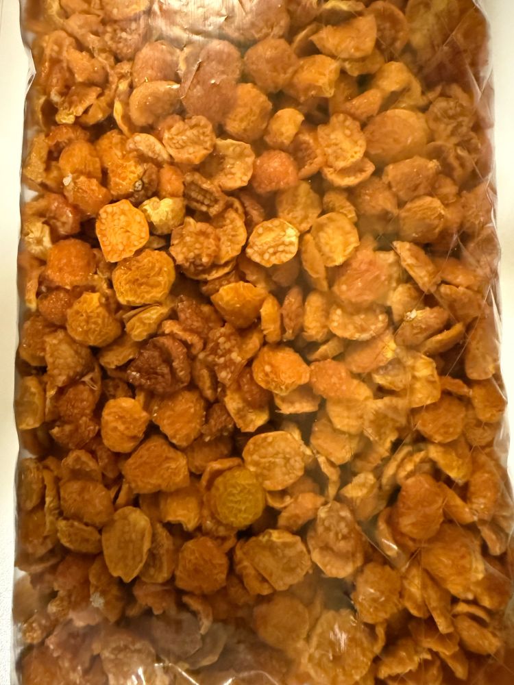 Sliced dried orange ground cherry berries in a plastic bag.
