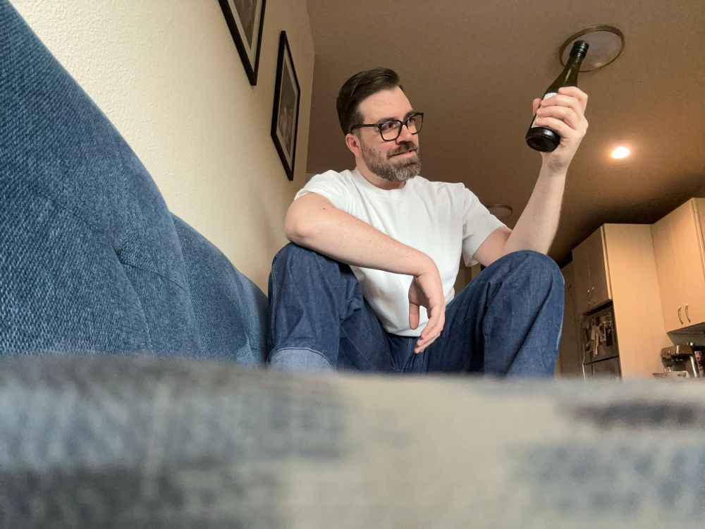 Artist pretending to cheers, tap a soda with a bottle of cheap sake. 