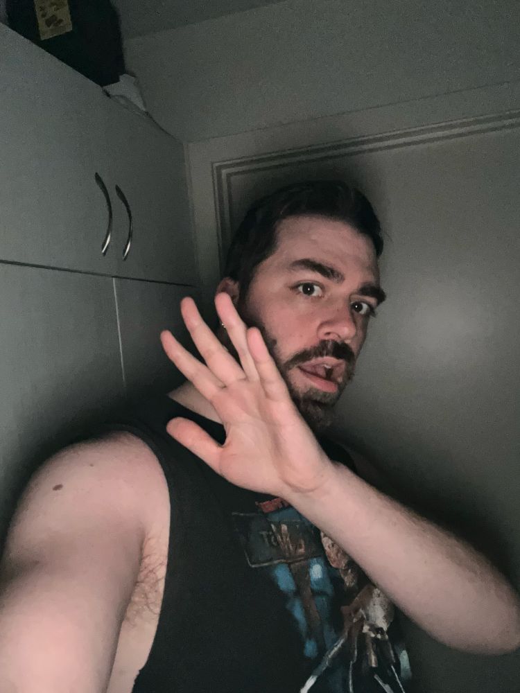 Desperate artist taking a flash photo, pretending to be shocked with hand in front of face.