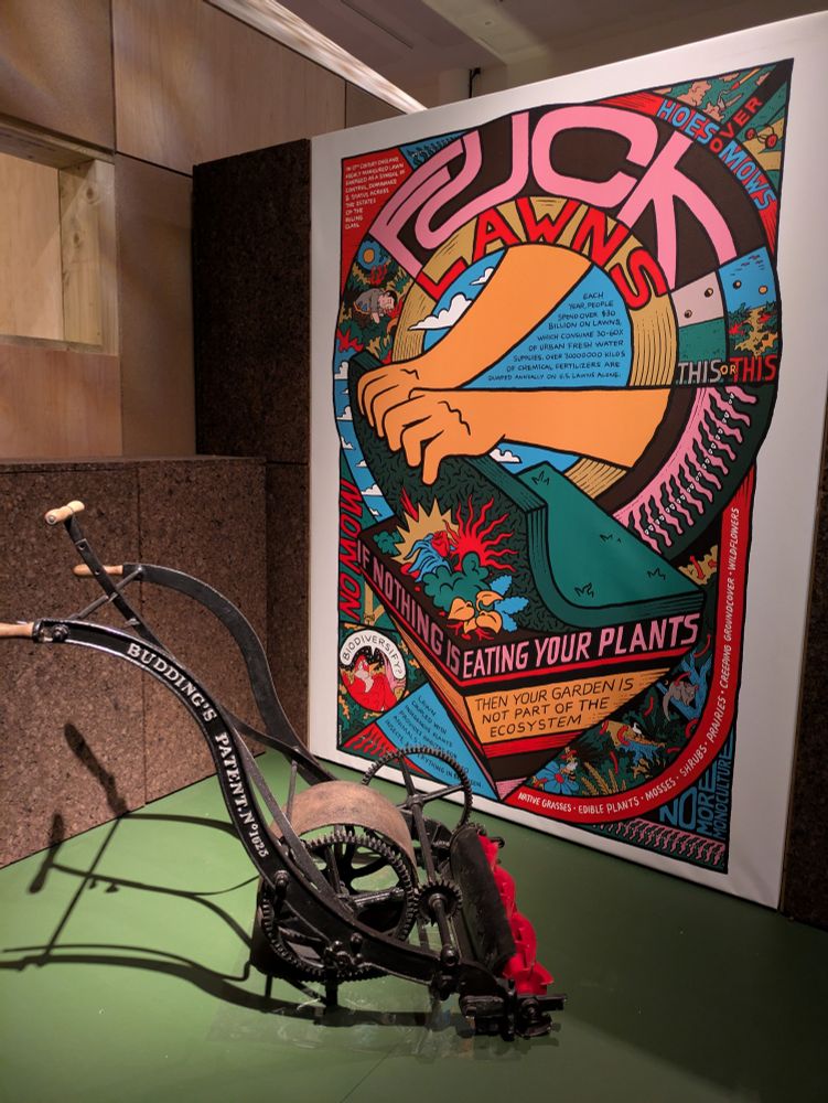 Edward Budding patented the first mechanical lawnmower, this is one of them from 1832. We have one in the Science Museum Collection but this one is on loan from Ransomes Jacobsen Ltd. Behind it is a colourful poster entitled "Fuck Lawns" which decries the typical garden lawn as an unsustainable monoculture. The art is by Sam Wallman. Weirdly the label didn't carry a date but I think it's from 2022.