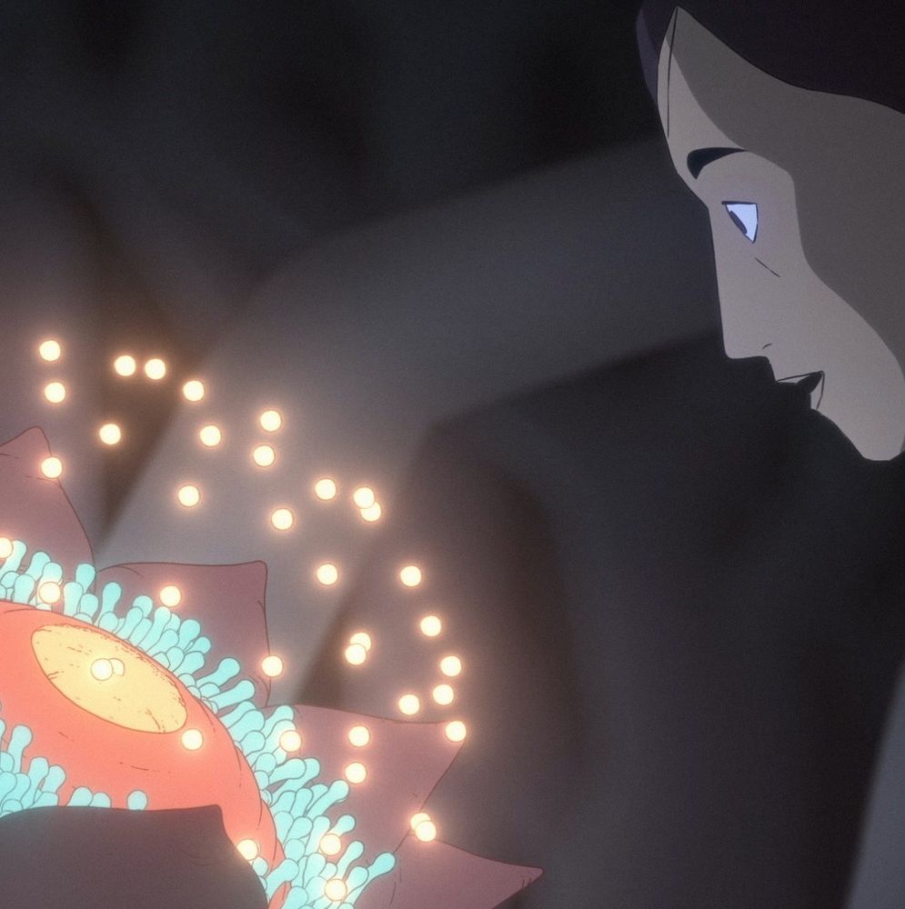 One of the characters watched the pollination sequence of a strange flower, glowing balls rise towards her face from and orange and yellow plant with short tendrils surrounding it