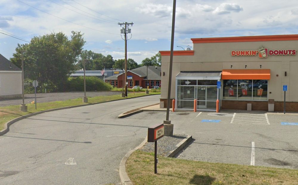 A U.S. Postal Service building visible in the background with a Dunkin' Donuts in the foreground.