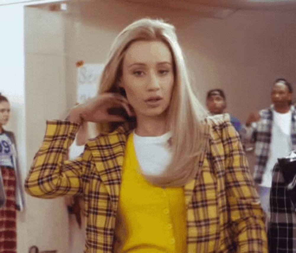 a woman wearing a yellow plaid jacket and a yellow sweater with the number 99 on it