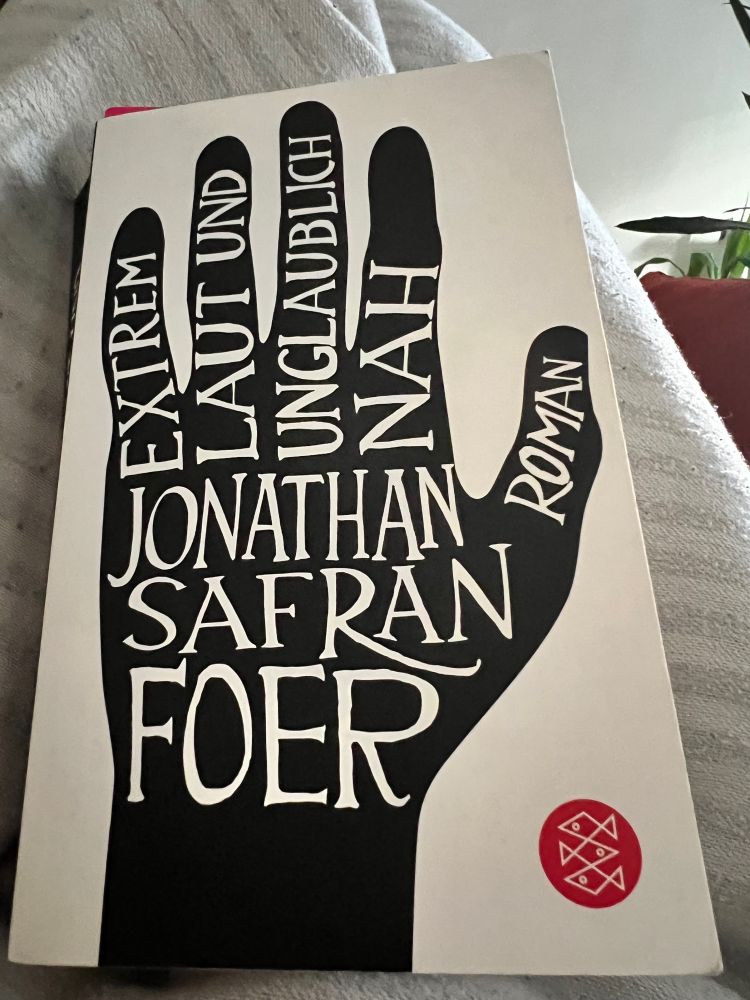 Buchcover: weißer Hintergrund, auf dem eine schwarze Hand gezeichnet ist. Auf dem Handrücken in weißen Versalien: Jonathan Safran Foer. Im kleinen Finger steht EXTREM, Ringfinger: LAUT UND, Mittelfinger: UNGLAUBLICH, Zeigefinger: NAH, Daumen: ROMAN