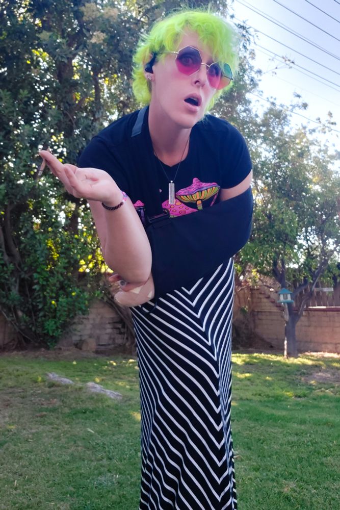 Timer selfie of me
Black & white striped skirt
Psychedelic crop top
Shoulder sling
Purple motherboard chip necklace
Red & blue hexagonal sunglasses
Fluorescent green hair

My backyard