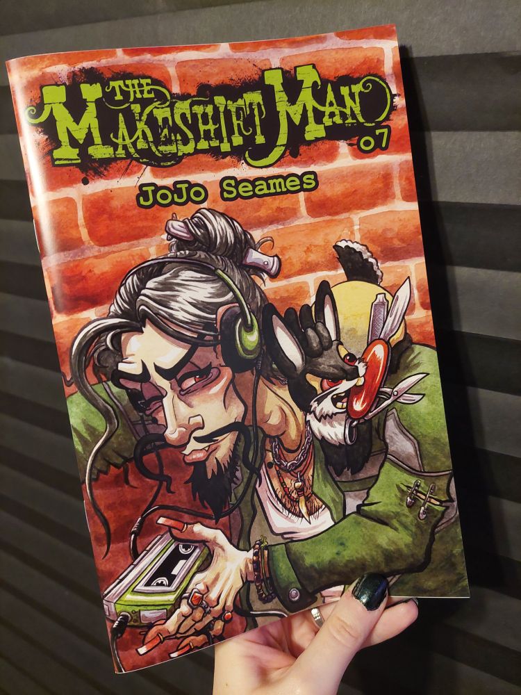 A photo of JoJo's hand holding a physical, printed copy of The Makeshift Man issue 7.