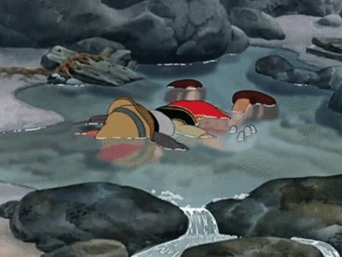 An animated gif of Pinocchio lying face-down in a shallow pool of water.