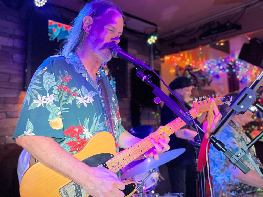 Slimtones guitarist Jeff Jordan with psychedelic lighting on stage.
