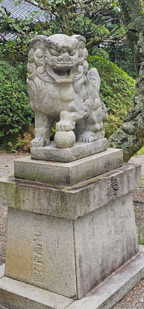 Komainu shrine guardian with paw on a ball
