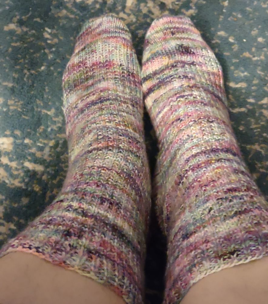 Hand knit socks in a riot of pinks purples and greens