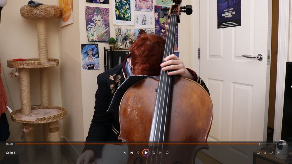 a screenshot of a video recording of me in full recording get-up with my cello. I am resting my head on the shoulder of the cello in a picture of utter exhaustion, my face buried in the shoulder pillow.