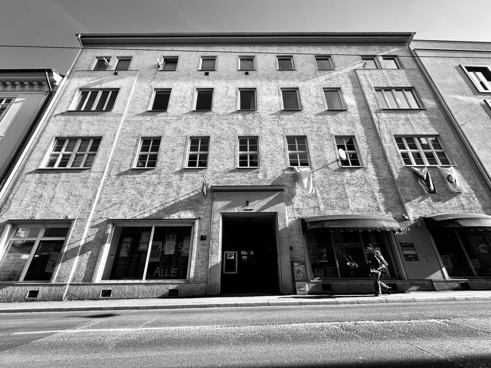 schwarzweiß foto von einem dreistöckigen mietshaus 