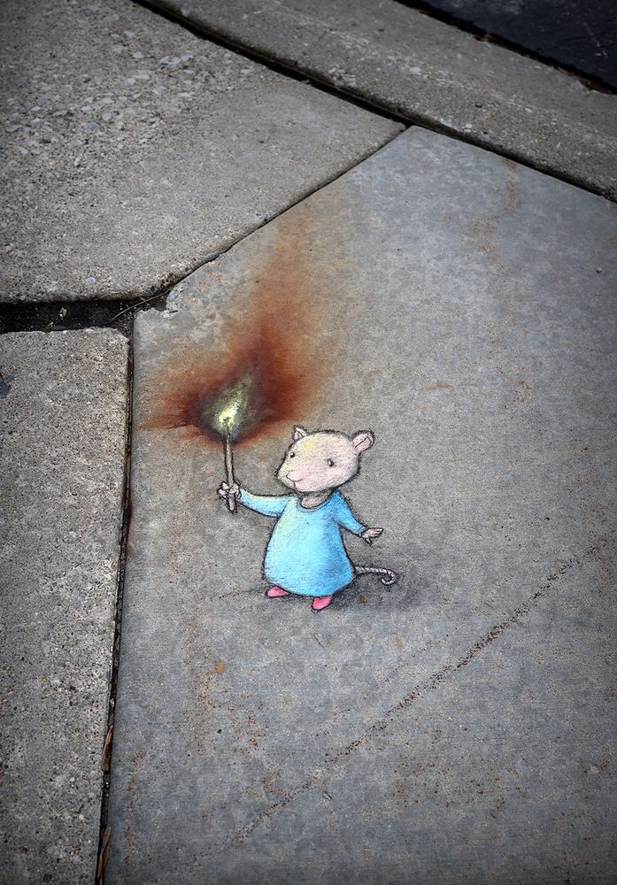 photo of a chalk drawing of a mouse holding a lit match, the flame of which is made of a rust stain on the sidewalk