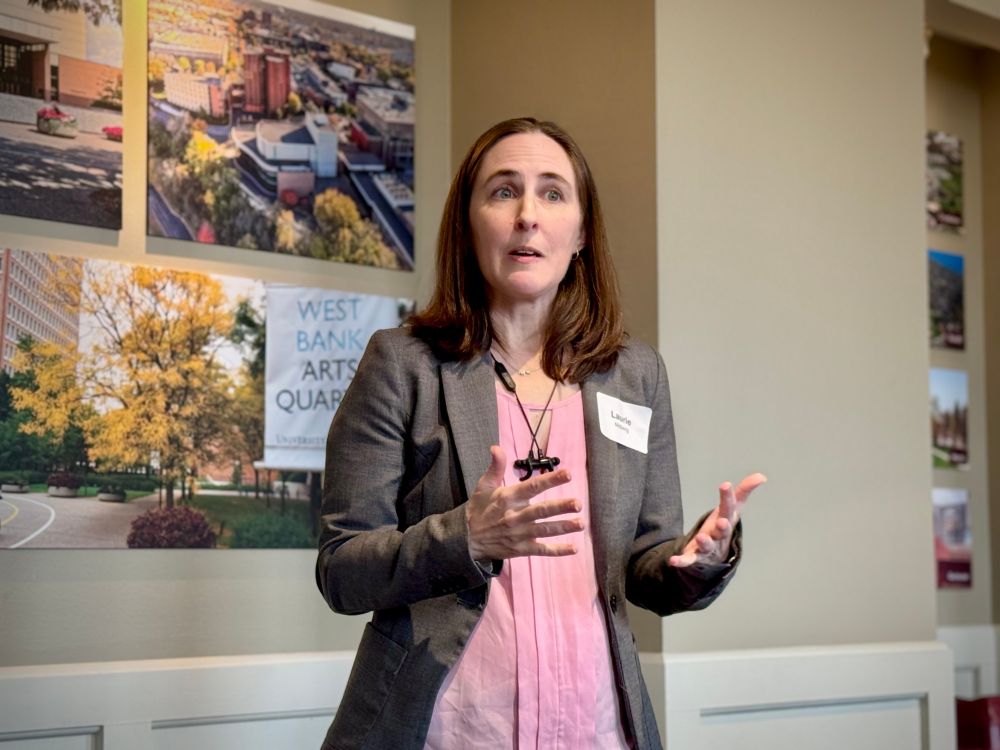 Open Rivers Editor Laurie Moberg gesturing as she speaks on stage.