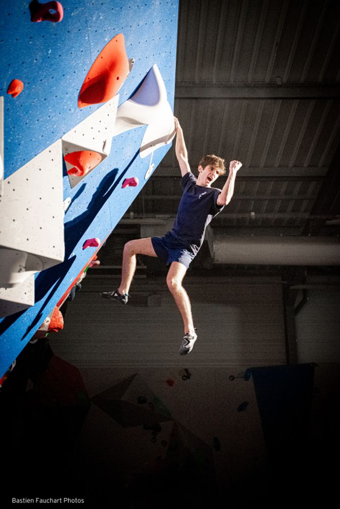 Personne faisant de l'escalade, célébrant son arrivée au sommet. Couleurs