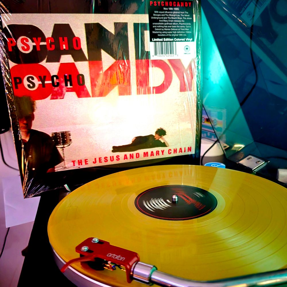 40th anniversary pressing of the album titled "Psychocandy" by the Jesus and Mary Chain spins in a turntable. The album sleeve is next to the gold colored vinyl. 
