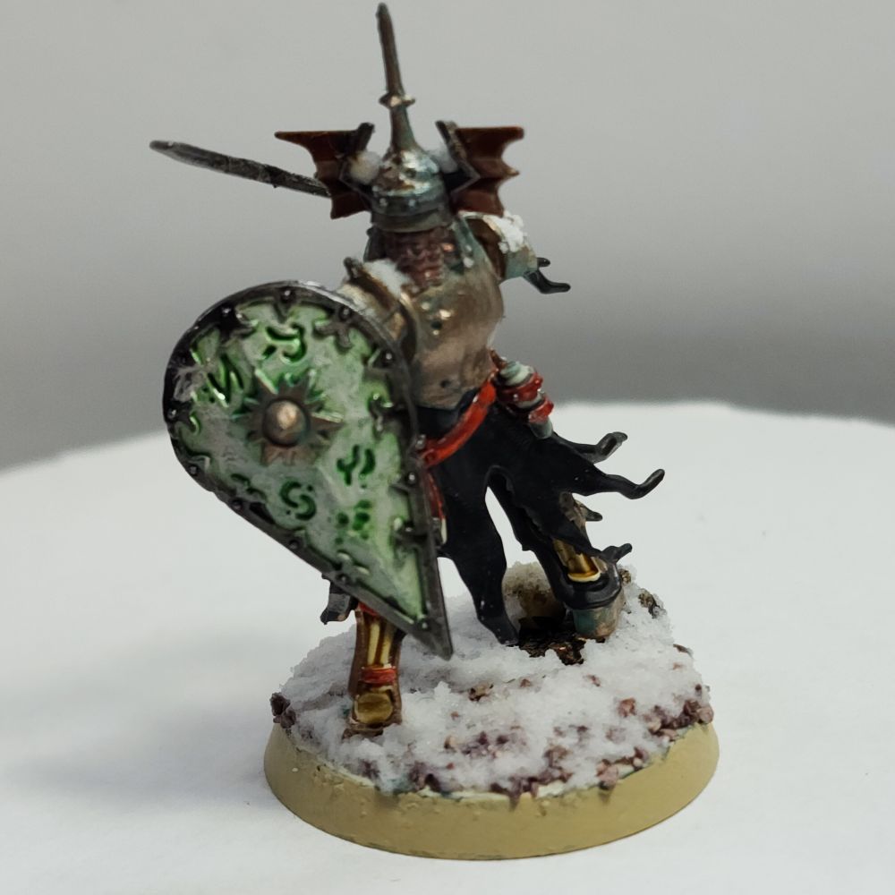 The same miniature as the last two pictures this time from behind showcasing itsrune encrusted shield. The shield is off-white with a metallic trim and has rotten and green glowing runes in it