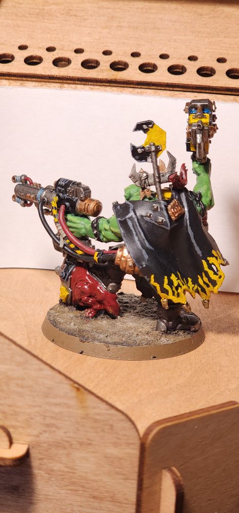 A back picture of a 40K ork wielding a large hammer and a ridiculous gun mounted on a Squig. 