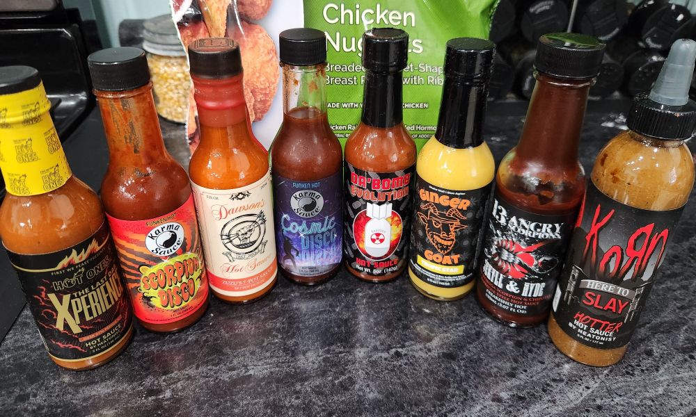 Row of hot sauces I will have to suffer tasting for charity.