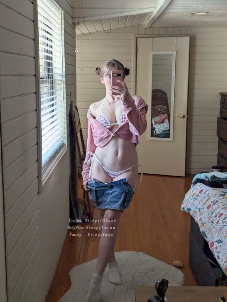 sleepy fawn wearing a denim mini skirt, pink cropped hoodie, and a pink and white striped bikini set