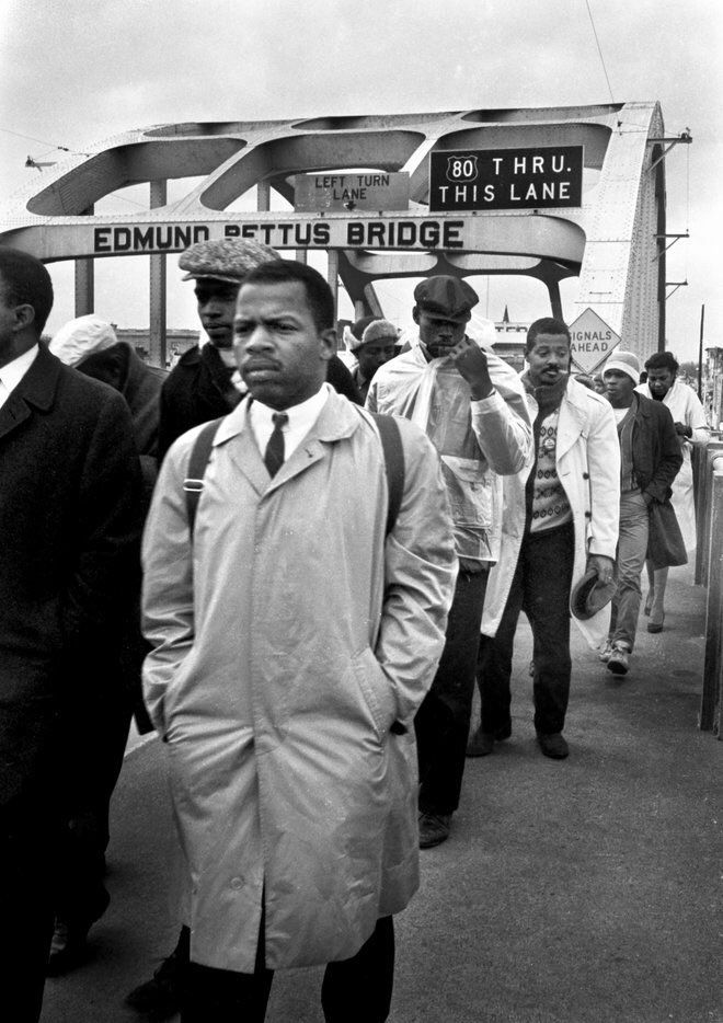 a young John Lewis, with many other african american civil rights protestors, crossing edmund pettus bridge