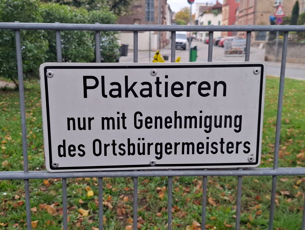 Schild an einem Zaun in Bodenheim: "Plakatieren nur mit Genehmigung des Ortsbürgermeisters"