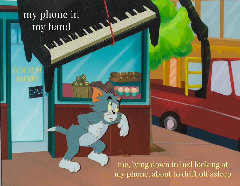 a piano is hanging on a rope next to the text “my phone in my hand.” beneath the piano, tom from tom and jerry carefully walks while next to the text “me, lying down in bed looking at my phone, about to drift off asleep”