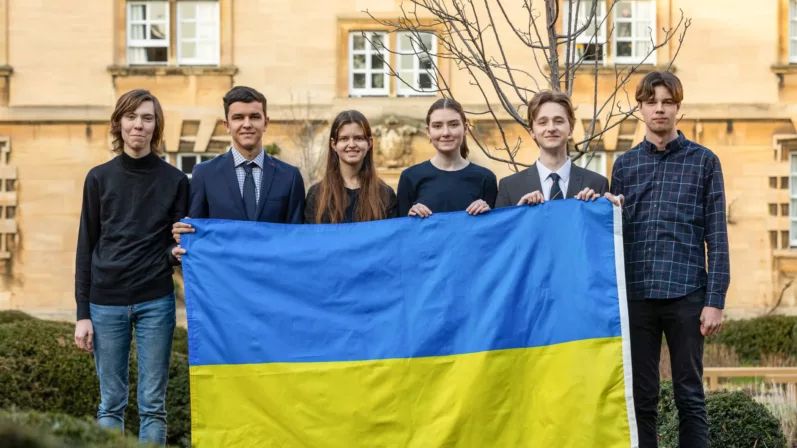 group of Ukrainian students holding up the Ukrainian national flag