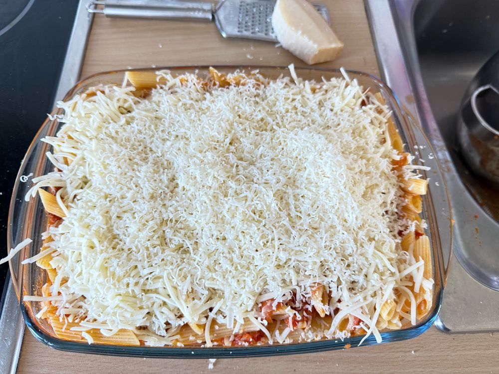 Una fuente pequeña con macarrones con tomate y chorizo picante de León. Queso rallado a cholón porque la vida son dos días y llevamos tres durmiendo. 