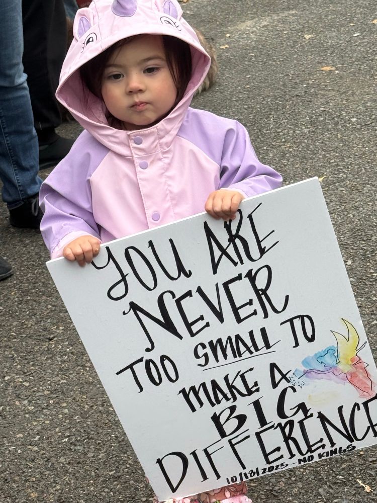 Adorable little girl holding cute sign saying you are never too small to make a big difference 