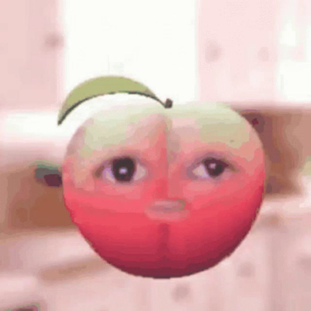 a red apple with a green leaf and a face on it