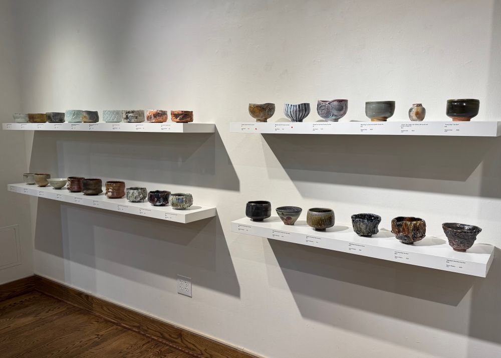 A set of four white shelves showing a wide range of teabowls from makers all over the world. 