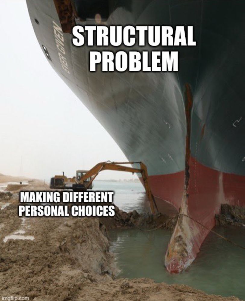 Photo of the stuck Ever Given-labeled Structural Problems”-with a small digger-labeled “Individual Choices”-trying but failing to dislodge it. 