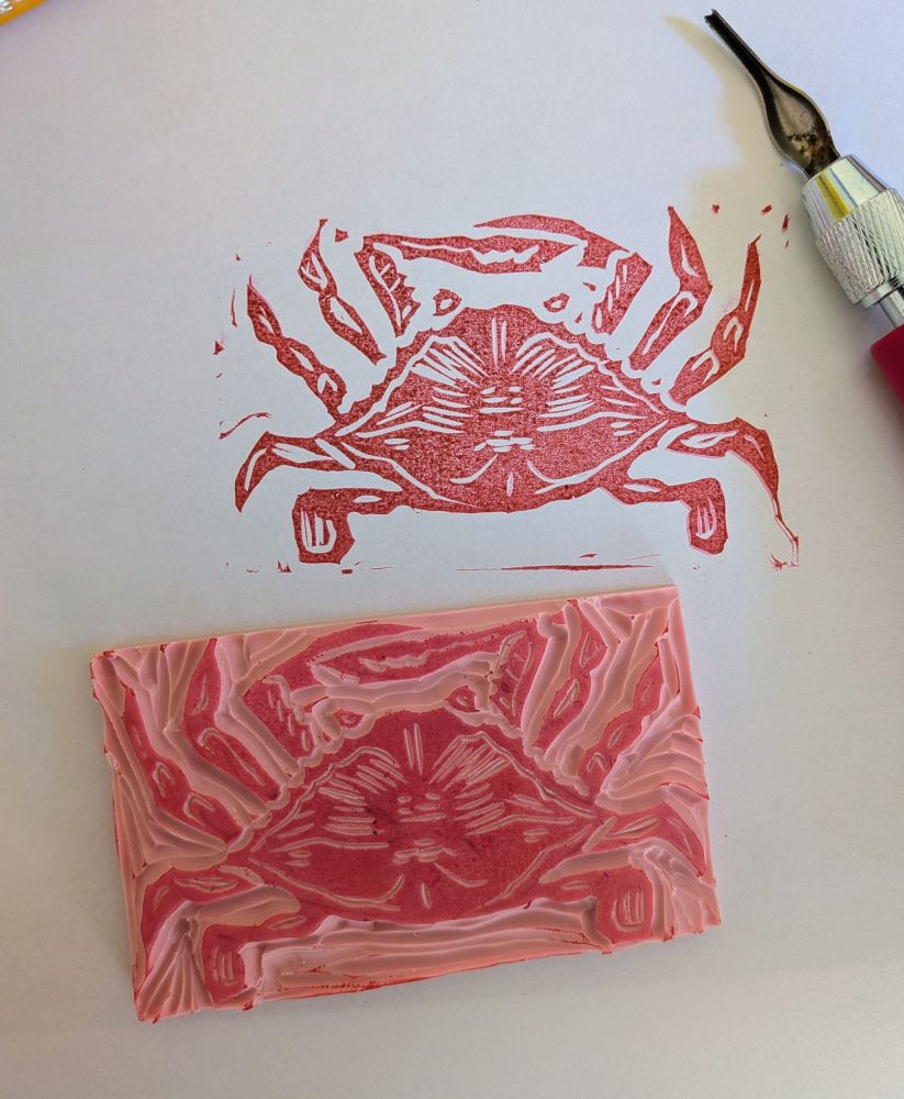 Red ink crab and stamp next to stamp cutting tool