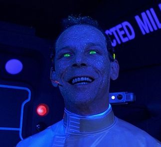 Professor Mactilburgh from the 5th Element. He is under a black light and glowing blue with green eyes