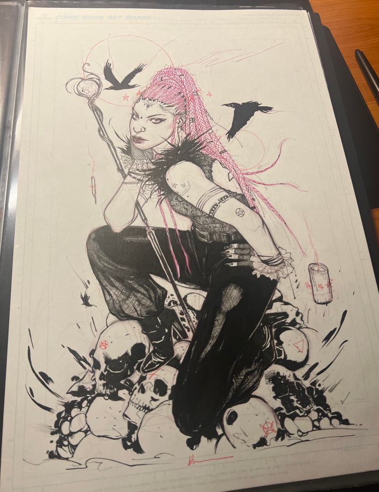 Woman in goth / witchy fashion kneeling on skull heads . 