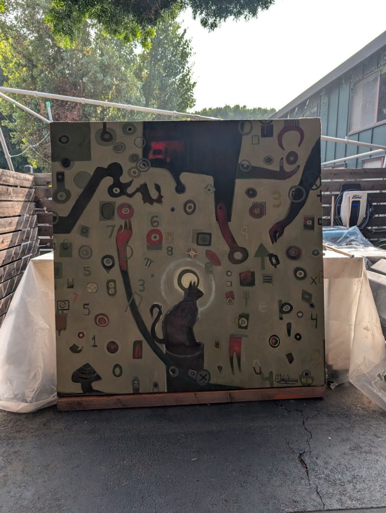 A large painting of a cat with a halo behind it and geometric shapes surrounding it