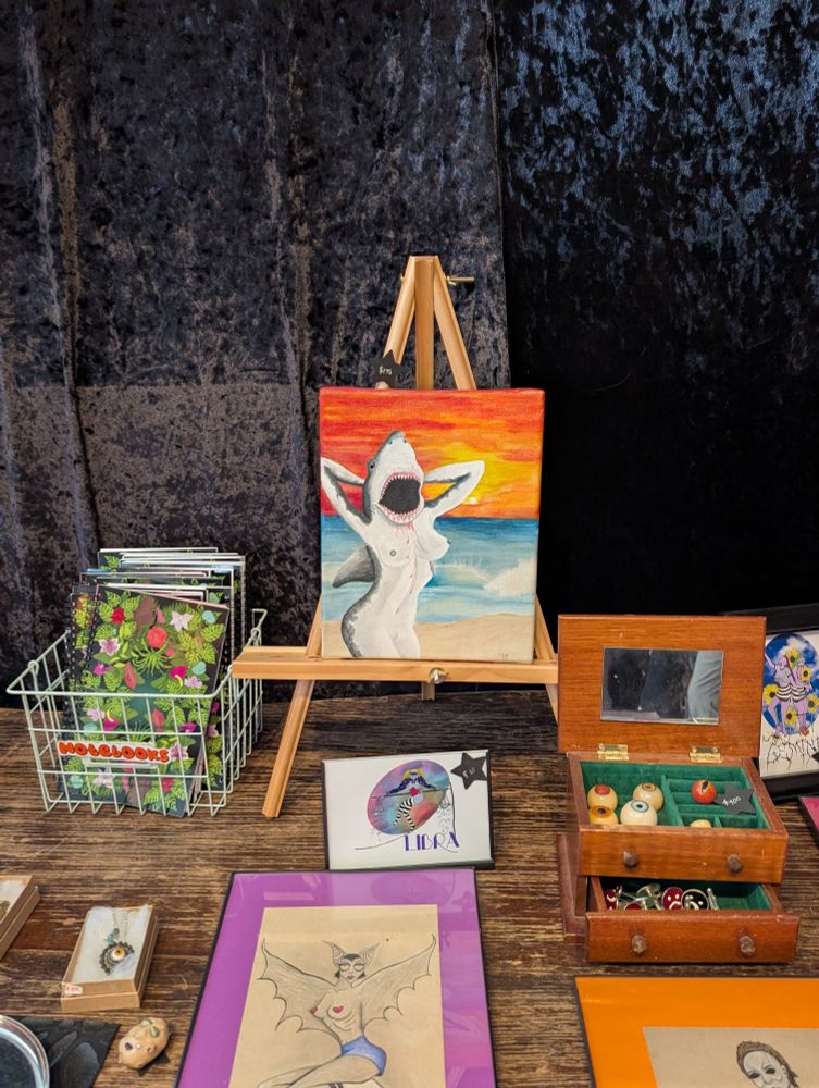 A humanoid shark baring her breasts among a number of other erotic works.