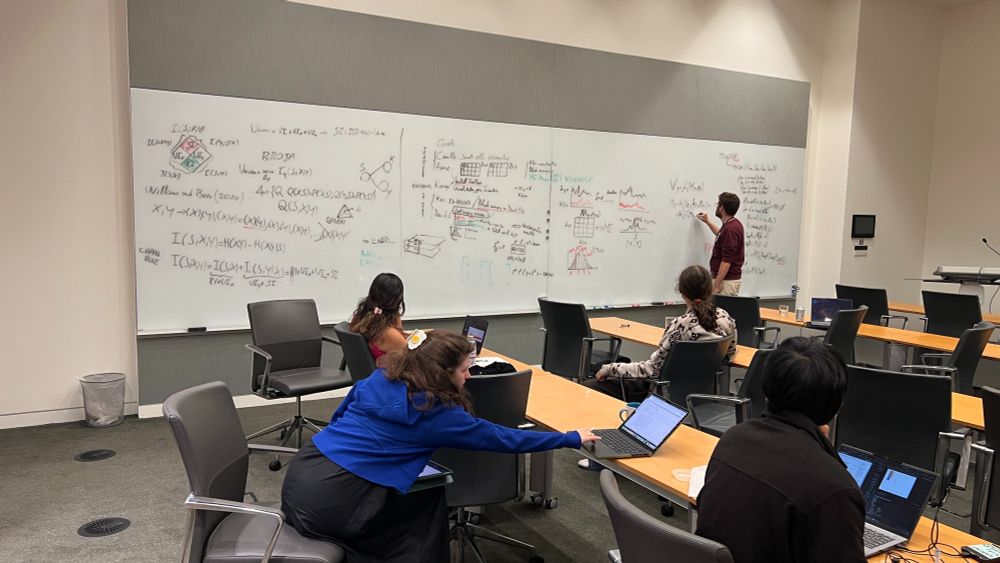 Marco Celotto works with a team on the whiteboard at NeuroDataReHack