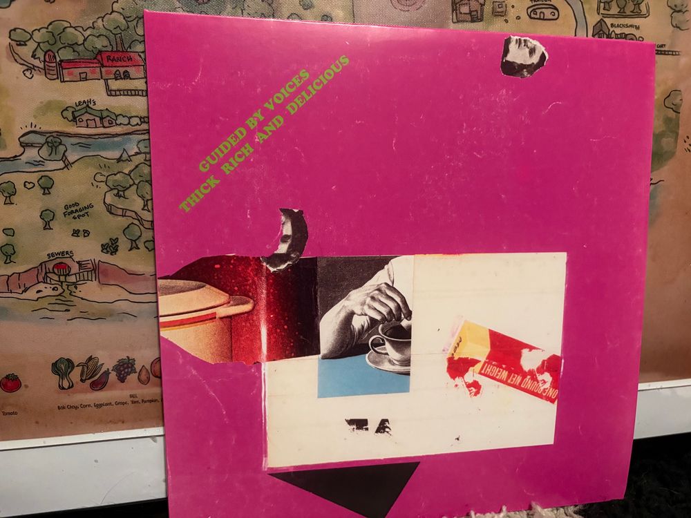 Vinyl copy of the Guided By Voices album Thick Rich And Delicious sitting in front of a map of the town from the video game “Stardew valley”