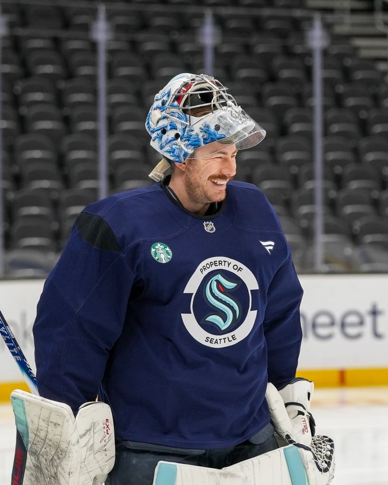 a photo of Seattle Kraken goaltender Philipp Grubauer beaming as he skates past the camera.