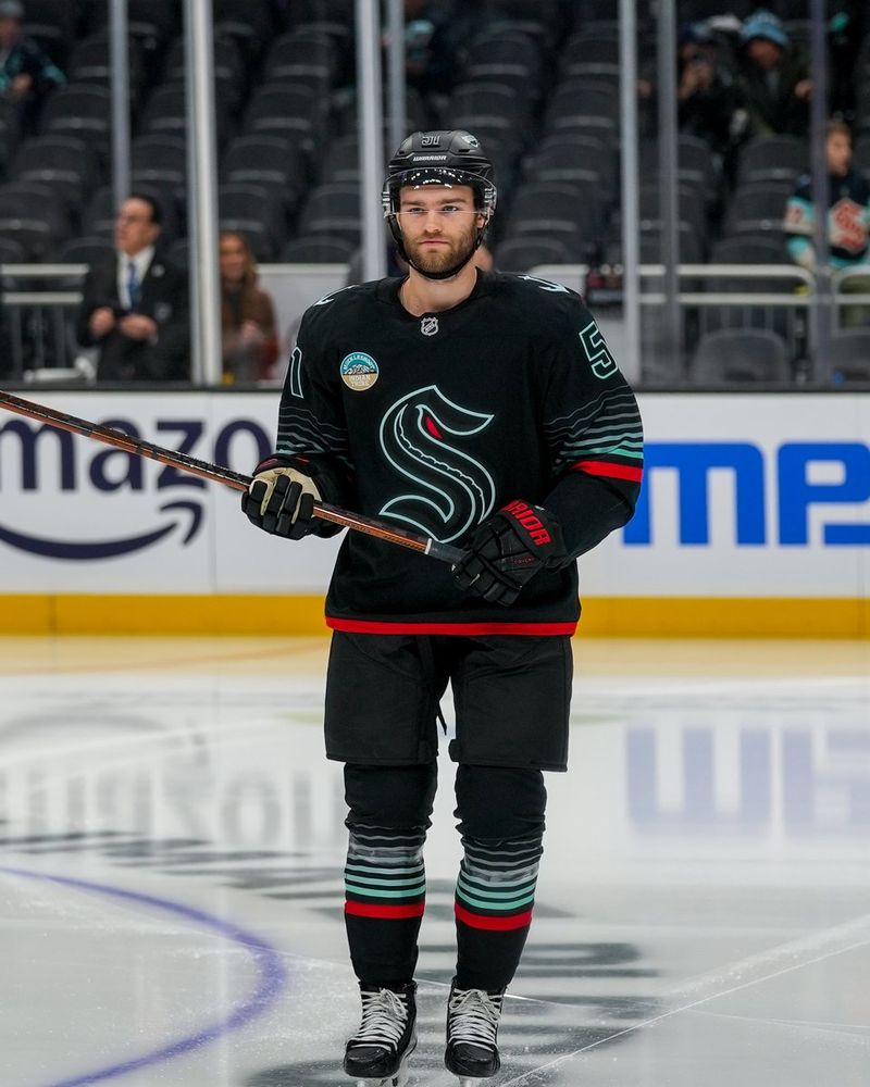 a photo of Seattle Kraken forward Shane Wright with a serious expression on his face, skating towards the camera.
