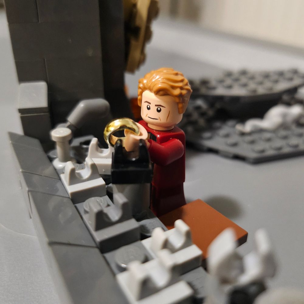 LEGO Celebrimbor seeming pleased with the Ring he forged as an ominous tool lingers next to him