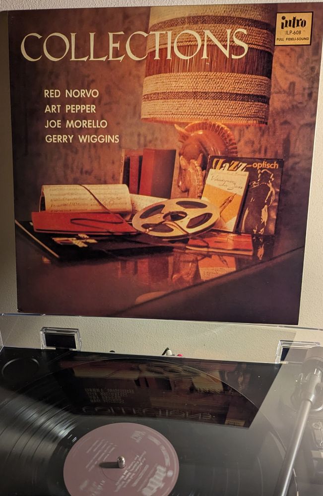 LP cover - an odd one. "The cover photo was taken by Ray Avery, well known west coast jazz photographer, at the fine furniture showroom of MONTEVERDI-YOUNG, 970 La Cienega, Los Angeles". It's a collection of items on a glass-topped table - a lamp with a base shaped like a mare and foal and a nice wool and wicker shade; two books by Joachim Ernst Berendt, Jazz-optisch and Variationen über Jazz; a reel tape, partly unspooled; unidentifiable sheet music; some folios and other books; and an LP I can't make out the name of, though it could be something "of classic jazz". Everything in the photo is a very 1950s brown, including the wallpaper out of focus behind the table.  