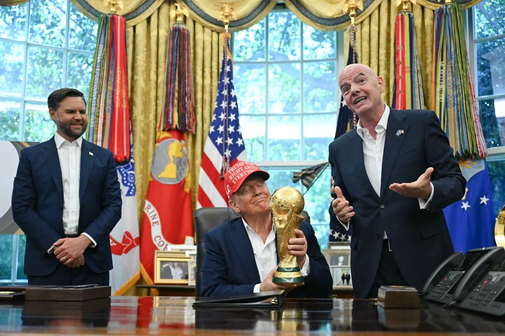 Senile old man fondles a golden trophy thinking it's his. Most corrupt sports official in history explains why this is good. Couch fucker stands by grinning.