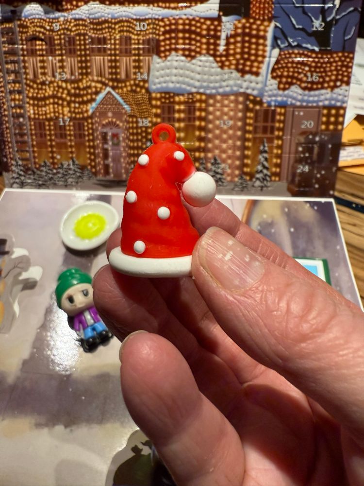 A plastic bright red Santa hat with white trim and a white pompom. It is covered in little white dots. It seems to have no connection to
the movie. 