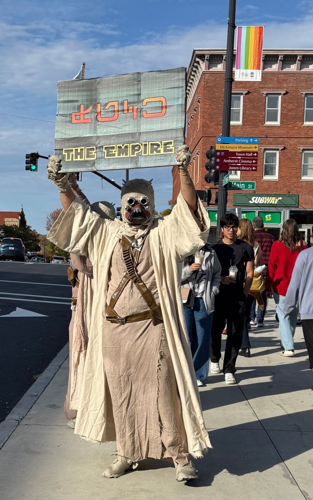 A Star Wars Tuskan Raider holding a sign that says something about the Empire in Tuskan 
