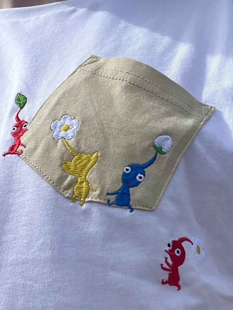 Closer detail of the embroidered Pikmin carrying a breast pocket on a T-shirt